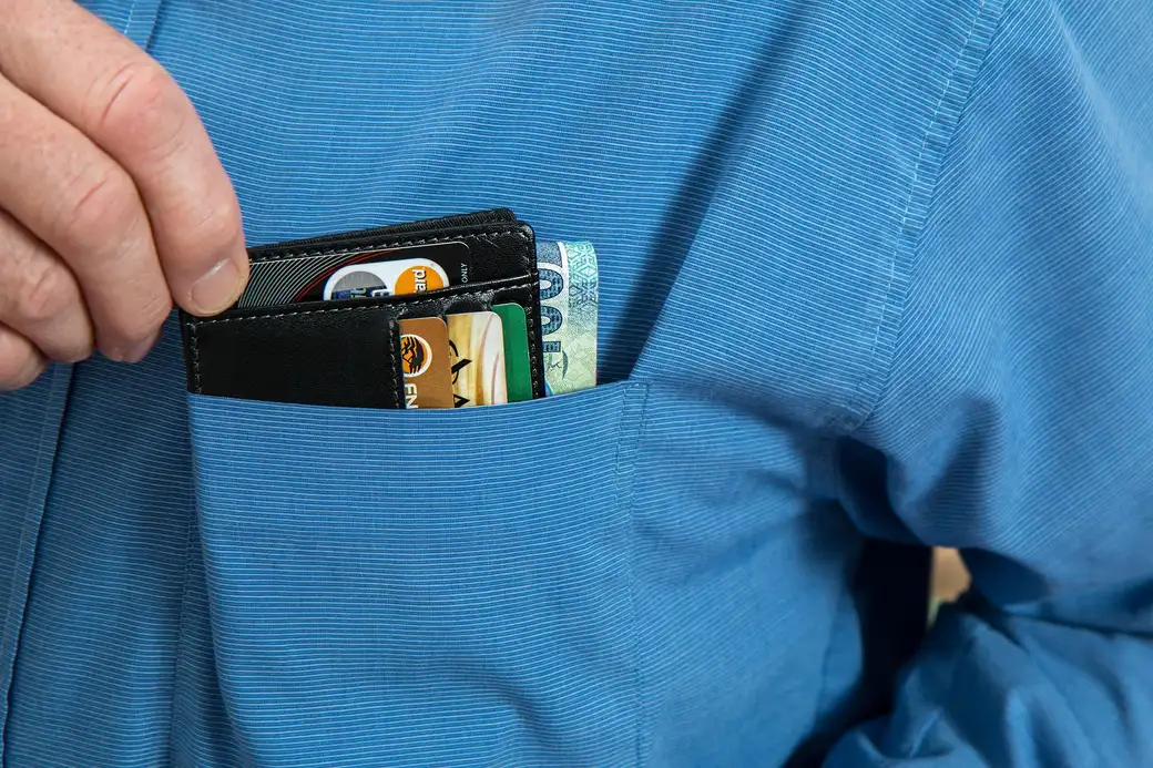 Hardware wallet device beside a laptop, illustrating the hardware plus software wallet combination